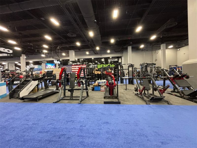 TZ Exhibitions 4 Trainer performing live demo using commercial fitness machine at the IHRSA event